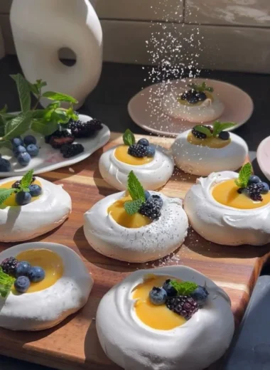 Meringues topped with vibrant citrus curd on a elegant plate