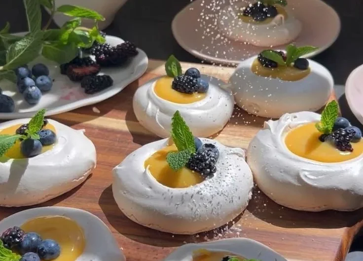 Meringues topped with vibrant citrus curd on a elegant plate