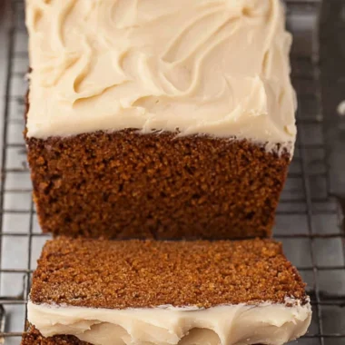 Freshly baked Gingerbread Loaf on a wooden table with festive decorations.