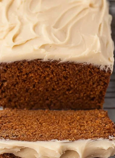Freshly baked Gingerbread Loaf on a wooden table with festive decorations.