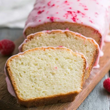 Delicious Key Lime Cake topped with raspberry glaze, showcasing vibrant colors.