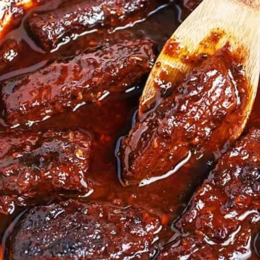Deliciously plated Korean Braised Short Ribs with rich sauce and garnish.