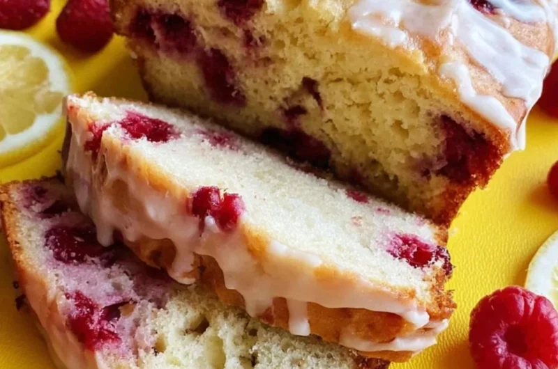 Sliced Raspberry Lemon Loaf with a drizzle of lemon glaze on a wooden board