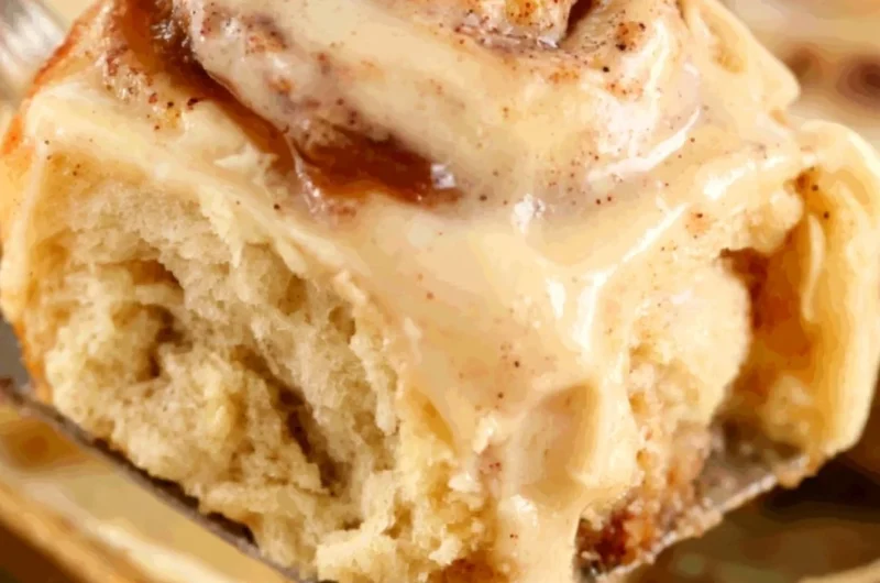 Freshly baked apple butter cinnamon rolls topped with icing.