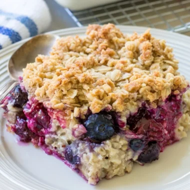 Delicious blueberry baked oatmeal served in a bowl with fresh blueberries on top.