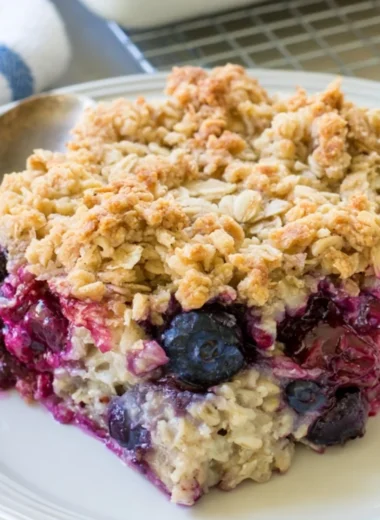 Delicious blueberry baked oatmeal served in a bowl with fresh blueberries on top.