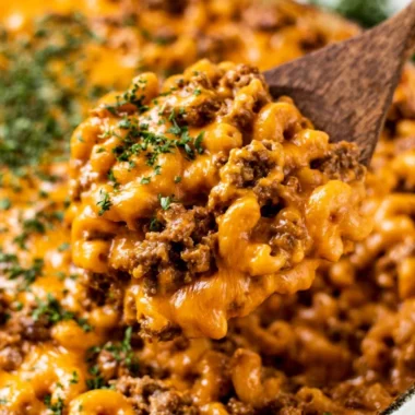 Cheeseburger casserole topped with cheese and herbs, ready to serve.