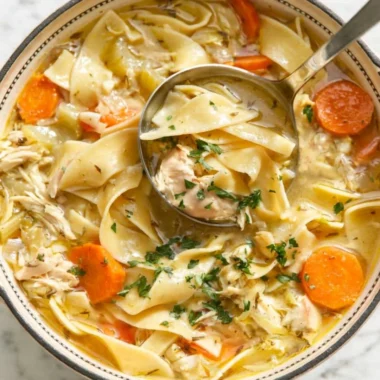 Bowl of easy chicken noodle soup with vegetables and herbs