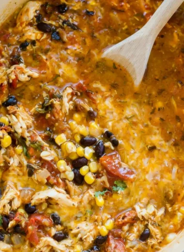 Bowl of easy chicken tortilla soup garnished with tortilla strips and avocado.