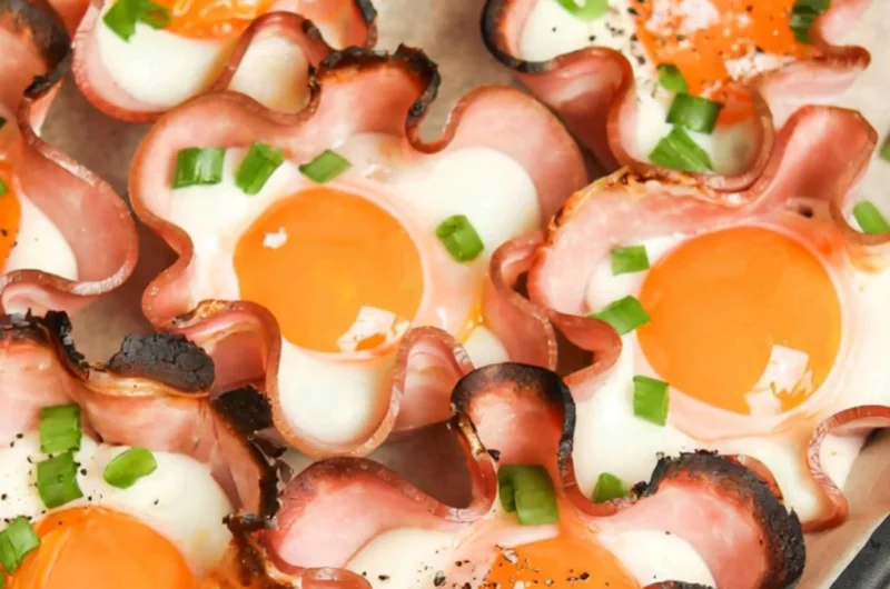Ham and Cheese Egg Cups baked in muffin tin, featuring fluffy eggs and deli ham.