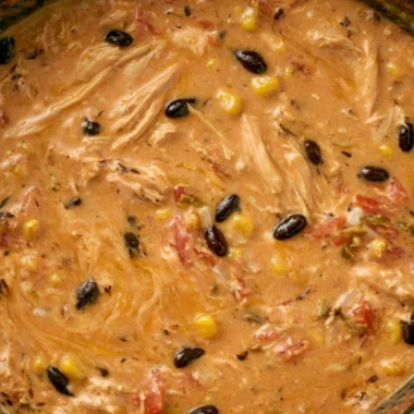 Creamy chicken tortilla soup in a slow cooker with fresh toppings.