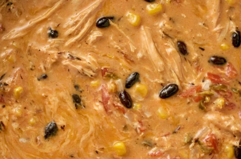 Creamy chicken tortilla soup in a slow cooker with fresh toppings.