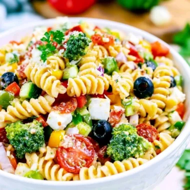 Bowl of the BEST Italian Pasta Salad with colorful vegetables and dressing