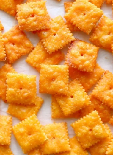 Homemade cheese crackers on a wooden platter, perfect for snacking.